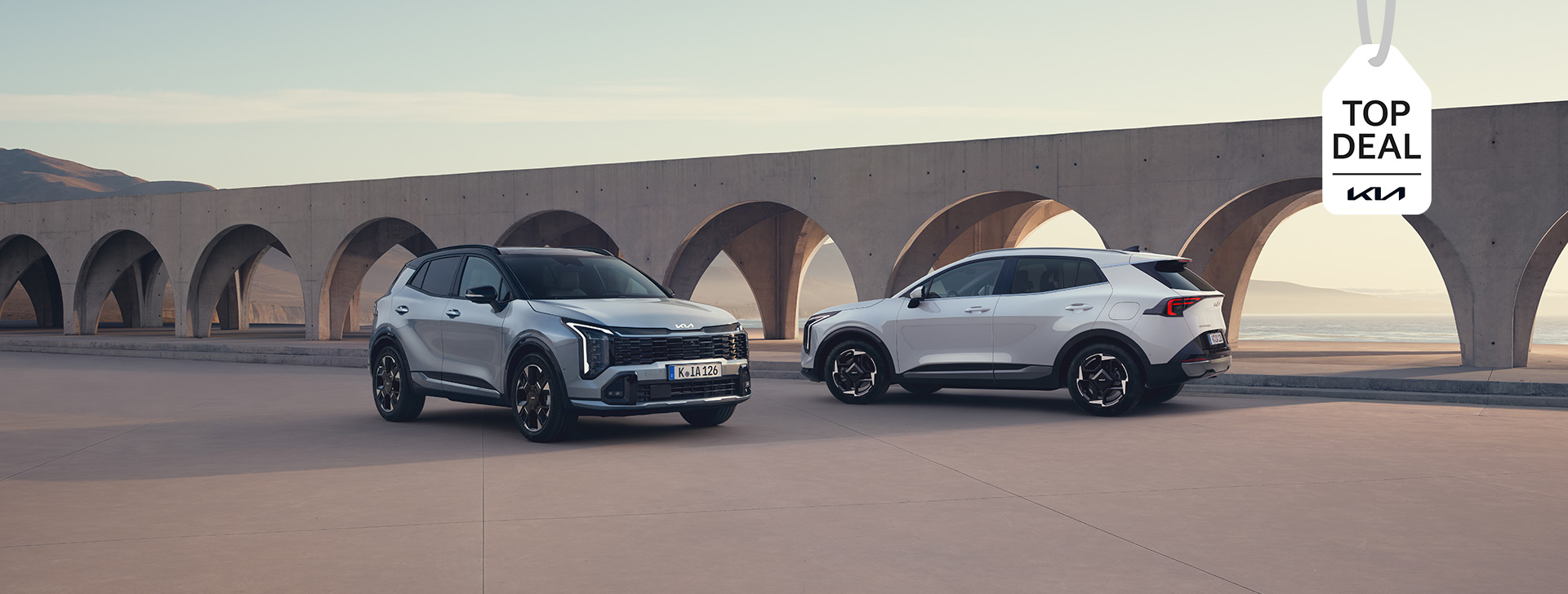 Zwei Kia Sportage vor einem Bogengang – Kia TOP DEAL